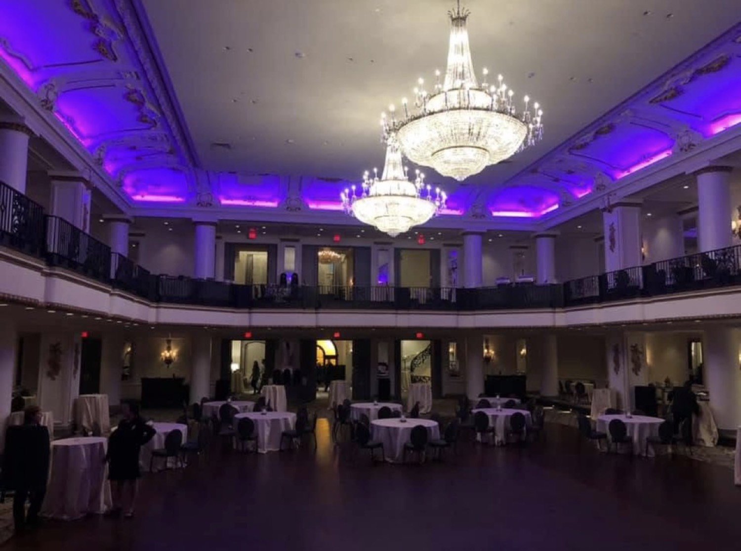 Grand ballroom with purple uplighting and crystal chandeliers